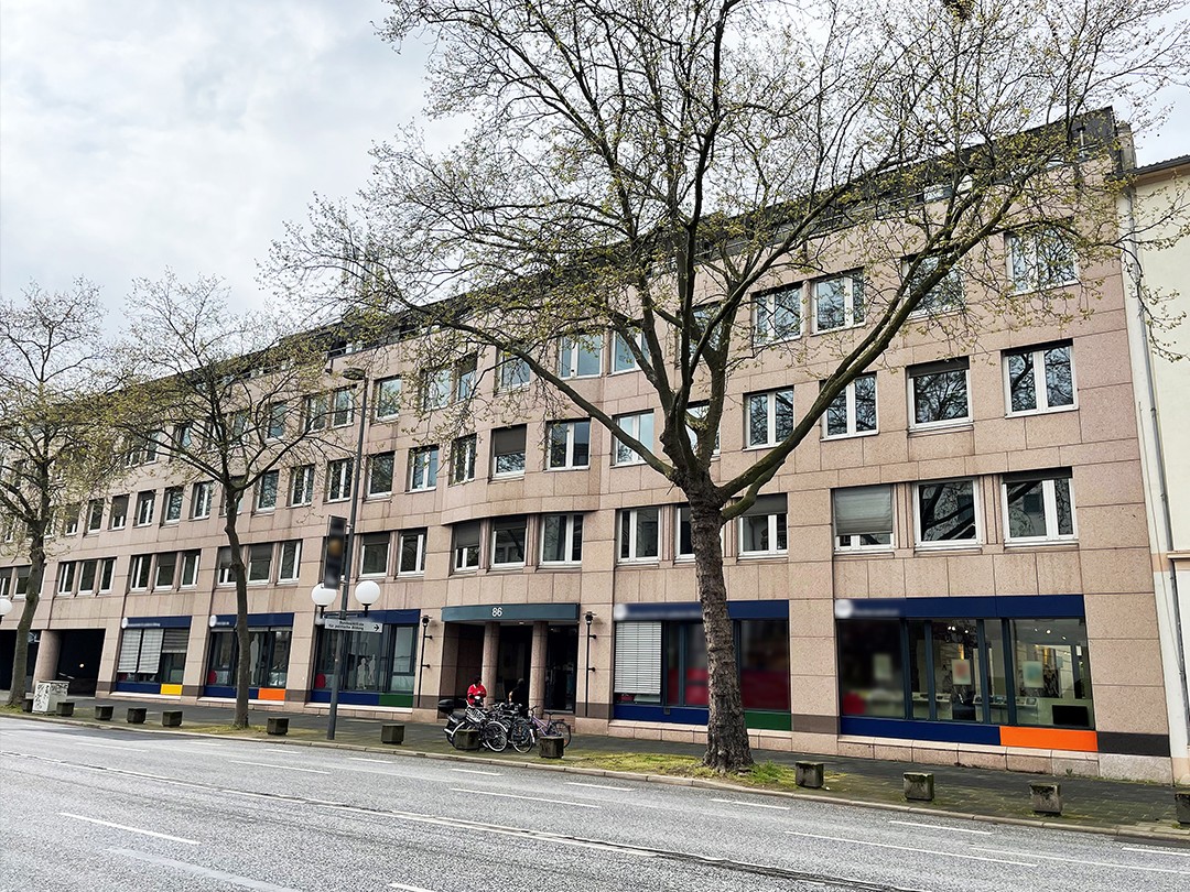 Ein Bürogebäude mit Bäumen davor.