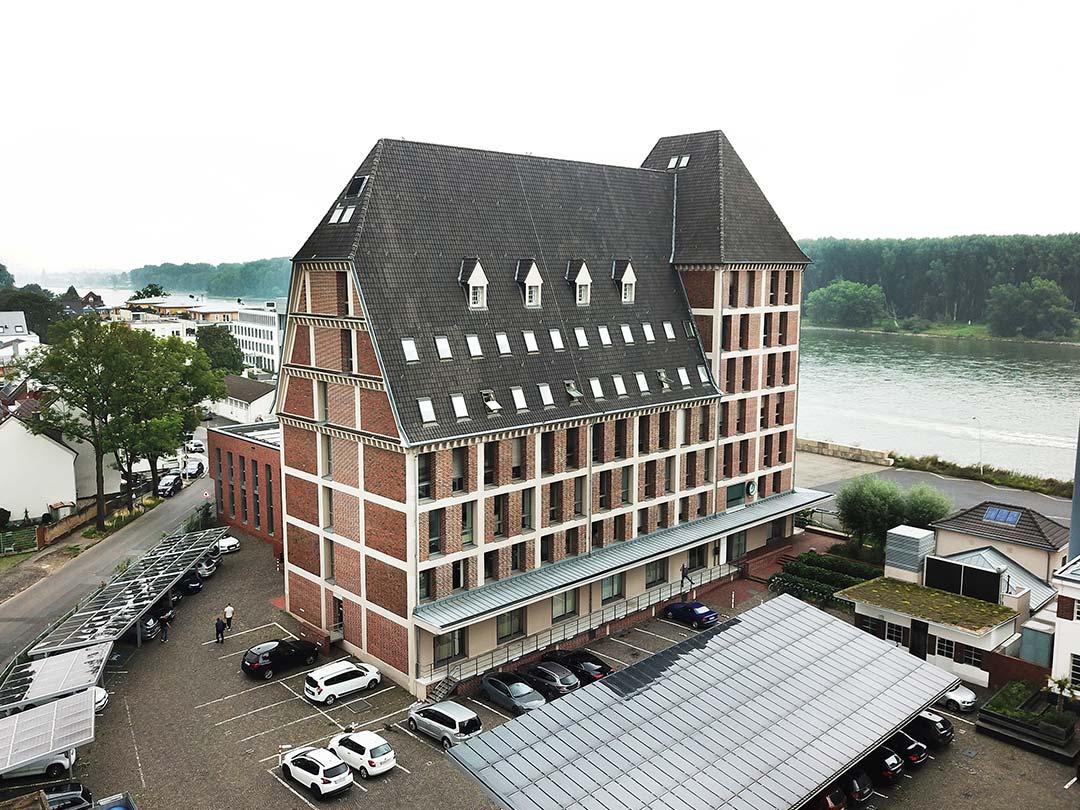 Großes Backsteingebäude am Flussufer mit Parkplatz