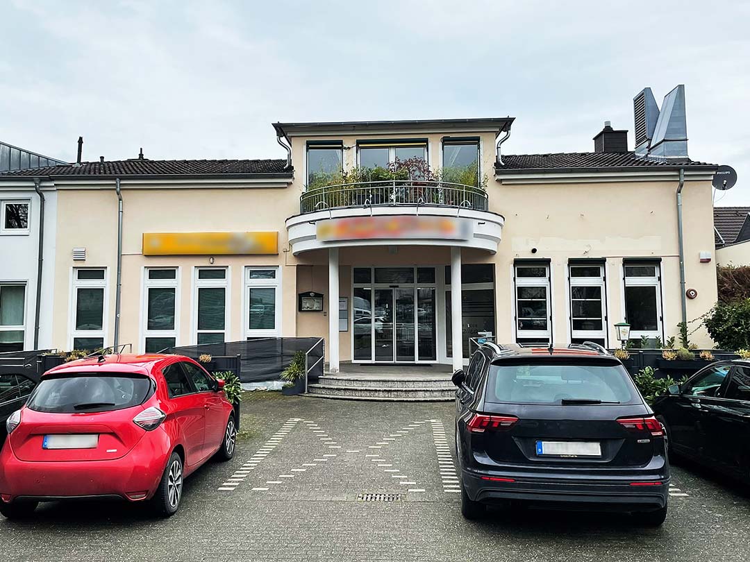 Gebäude mit zwei geparkten Autos davor