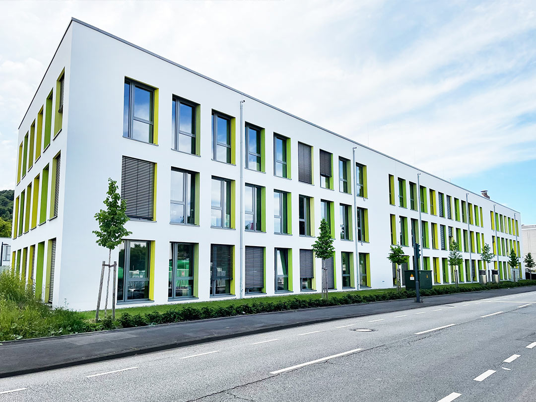 Modernes Bürogebäude mit grünen Akzenten.