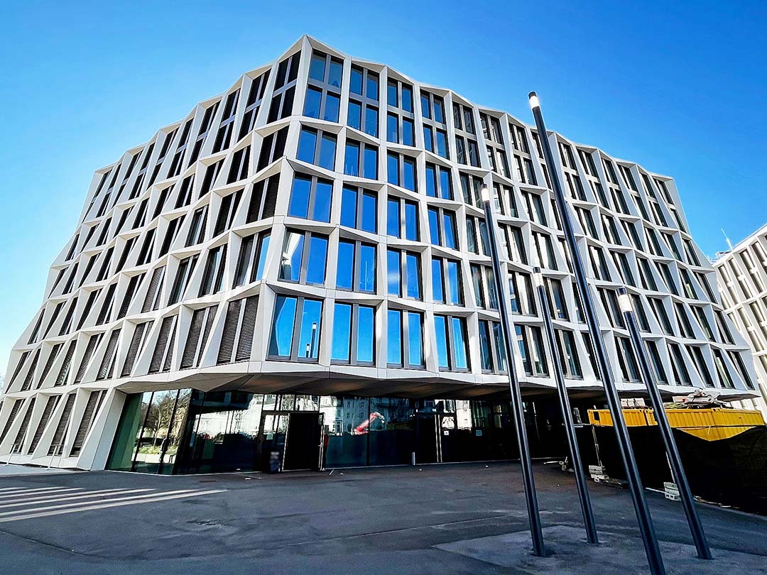 Modernes Gebäude mit Glasfassade bei klarem Himmel.