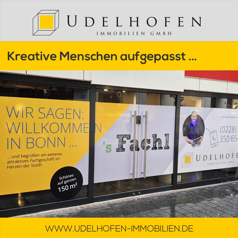 Schaufenster mit Werbeposter von Udelhofen Immobilien in Bonn.