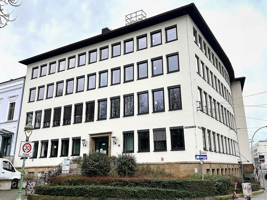 Modernes, mehrstöckiges Bürogebäude an Straßenecke.