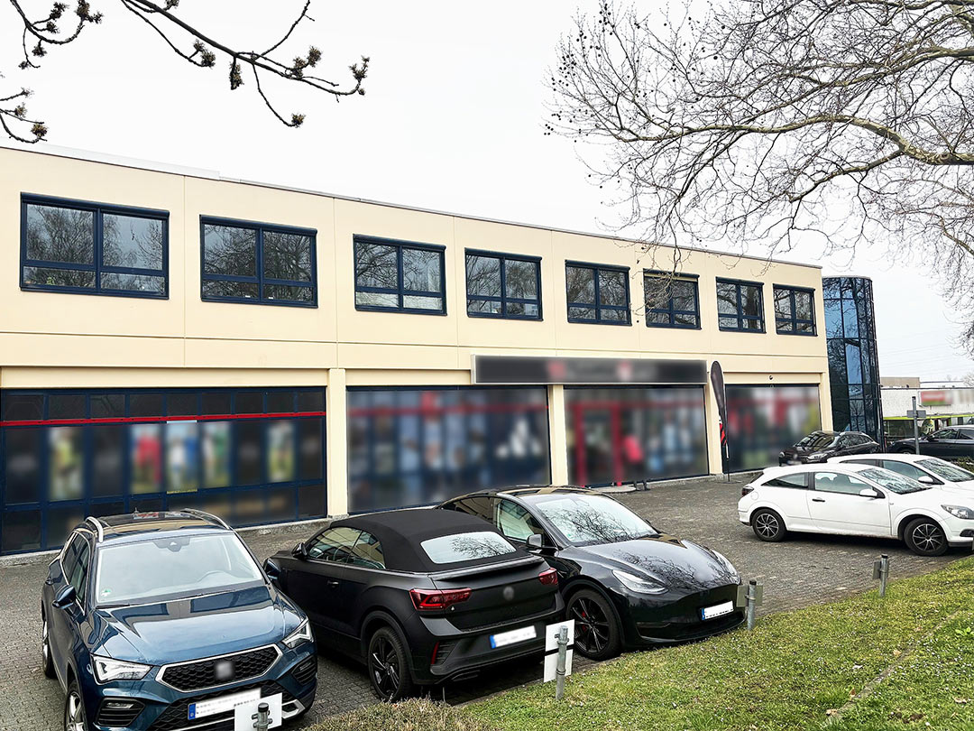 Parkplatz vor Bürogebäude mit Autos